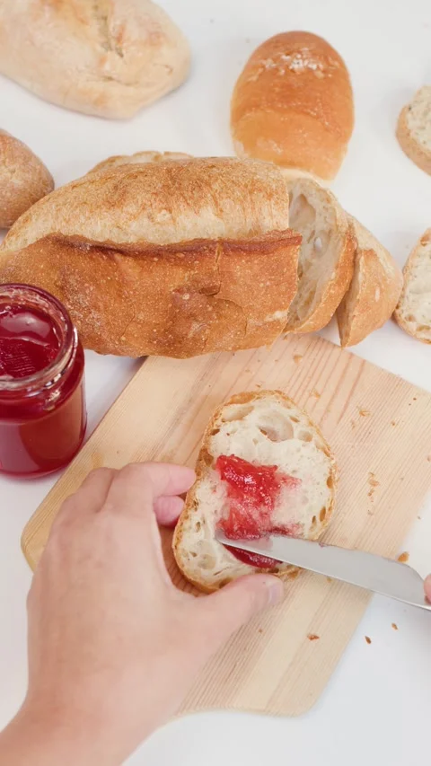 Spreading Red Strawberry Jam on Sourdough Bread Slice Stock Footage 337917704