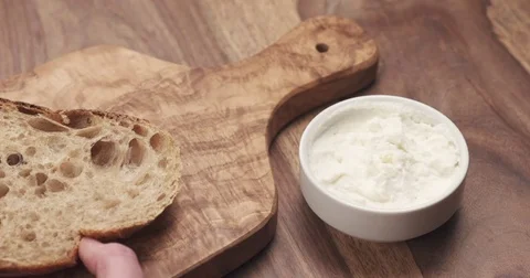 Spreading ricotta cheese on fresh rustic bread Stock Footage 75033505