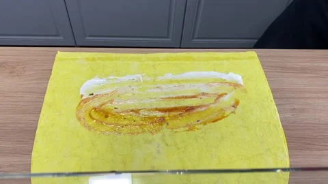 Spreading sauce and adding chopped cabbage on flatbread, shawarma preparation Stock Footage 318912181