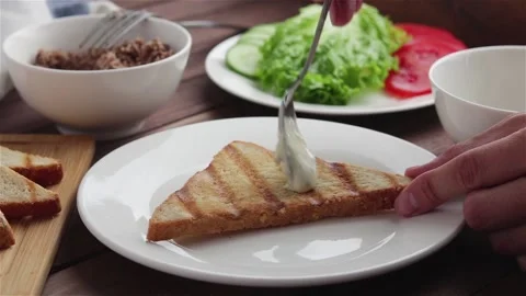 Spreading sauce on toast bread making sandwich Vidéo 108328979