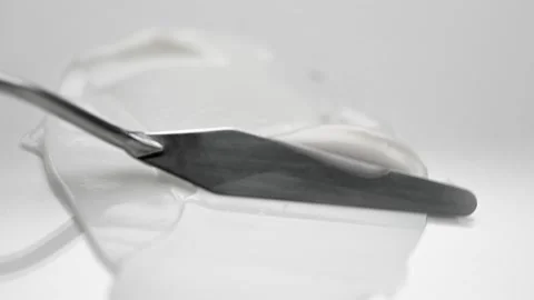 Spreading soft cream over white surface with metal spatula Stock Footage 170358050