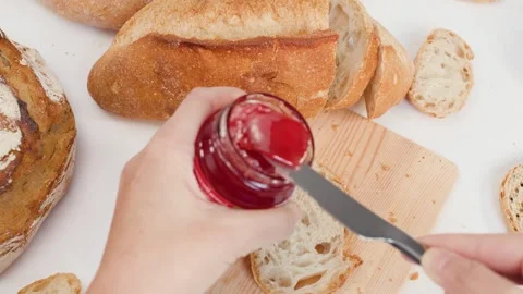 Spreading Strawberry Jam on Sourdough Bread for Breakfast Stock Footage 337767586