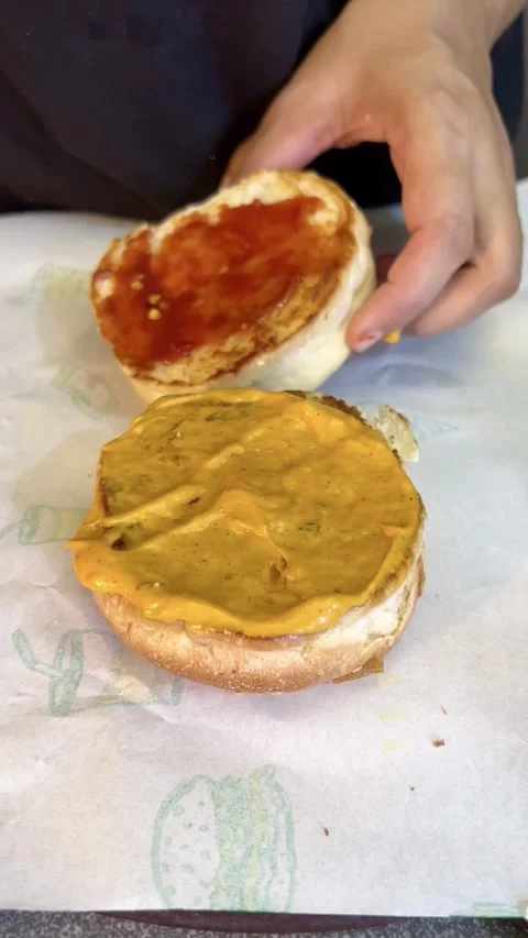 Spreading tomato catch up on a bread for making tikki Stock Footage 287176666