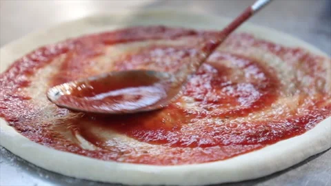 Spreading Tomato Paste on Pizza Dough Stock Footage 296023884