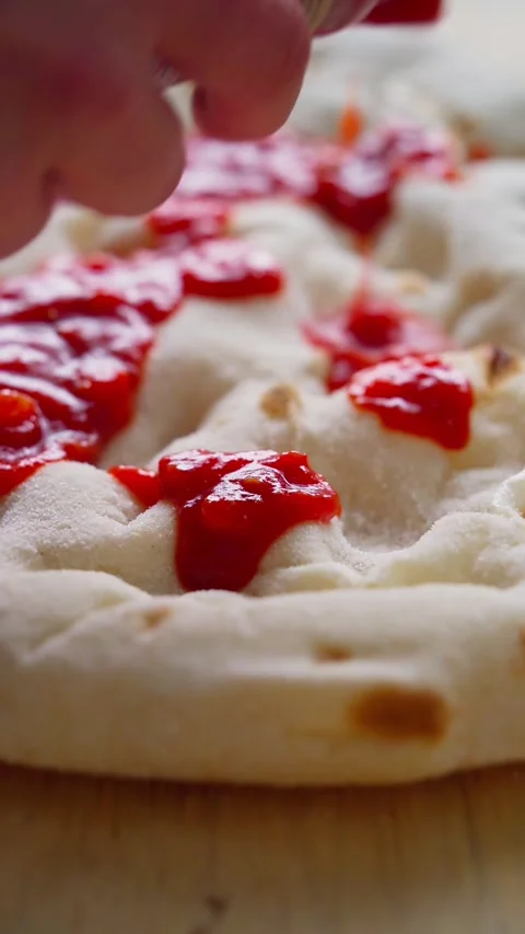 Spreading tomato sauce on the base of Pinsa Romana Stock Footage 307627172