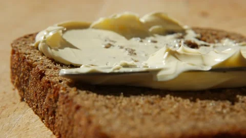 Spreading vegan butter on rye bread without dairy and eggs. Knife smearing soft Stock Footage 155149516
