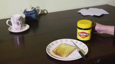 Spreading Vegemite on toast At the kitchen table Stock Footage 53763255