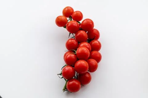 Sprig of red cherry tomatoes on the table. Stock Photos