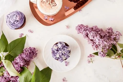 Spring aesthetic table setting. Purple french cupcakes on the golden tray Foto stock