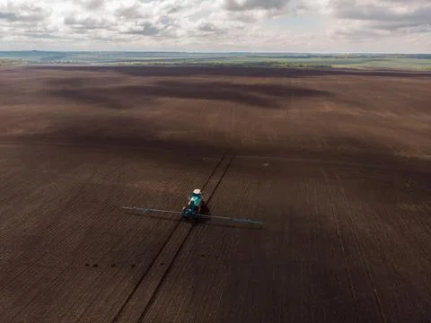 Spring agricultural work in the fields. The tractor sprays crops with herbicides Foto stock