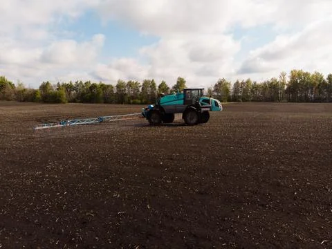Spring agricultural work in the fields. The tractor sprays crops with herbicides Stock Photos