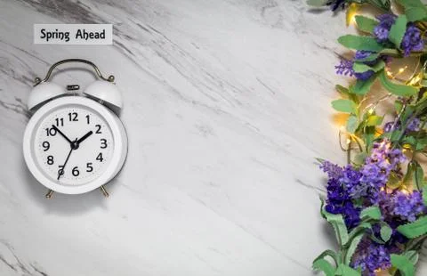 Spring ahead white clock and lilac sage flowers on gray marble (2) Stock Photos
