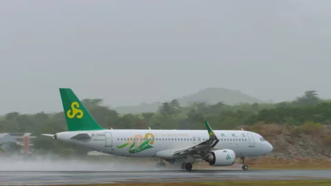 Spring Airlines Airbus A320-251N B-30D6 takeoff roll on wet runway in Phuket Stock Footage 337906356