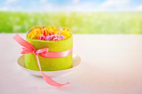 Spring and Easter concept. Small green cake with butter cream flowers on the  Foto stock
