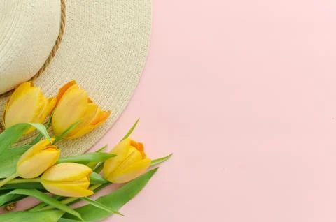 Spring background. Hat and yellow tulips over blue background, copy space. Top Stock Photos