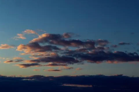 Spring blue sky background with orange purple clouds in the evening Stock Photos