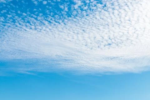Spring blue sky with fluffy clouds moved by the wind Stock Photos