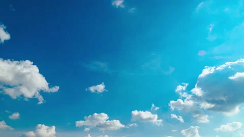 Spring blue sky with slowly moving white clouds, light flare, timelapse Stock Footage 151456045