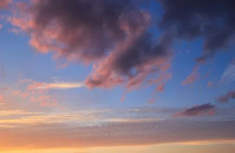 Spring blue sky at sunset with gray clouds. Stock Photos