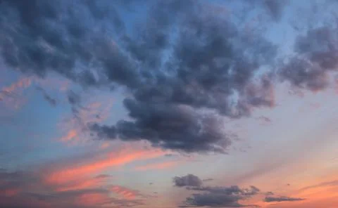 Spring blue sky at sunset with gray clouds. Stock Photos