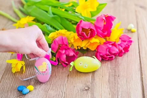 Spring bouquet with colorful easter eggs on a wooden background. Happy Easter Stock Photos
