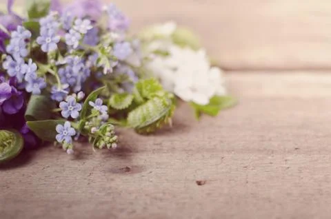 Spring bouquet with violets and forget-me-not flowers on a wooden background Stock Photos