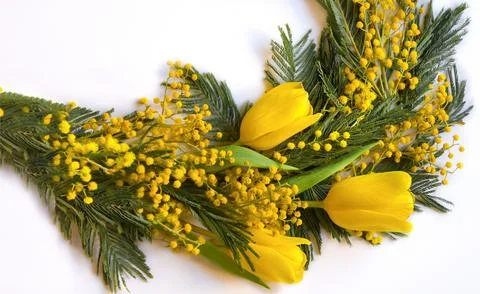 A spring bouquet of yellow tulips and mimosa is laid out in a semicircle on.. Stock-Fotos