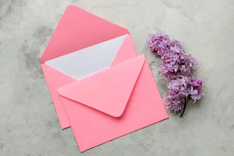 Spring branches of lilac and an envelope with a blank for text on a light bac Stock Photos