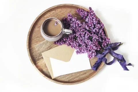 Spring breakfast scene. Blooming purple lilac branches, silk ribbon, cup of Foto stock