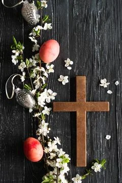 Spring cherry blossoms and Easter eggs and cross on old wooden background Stock Photos