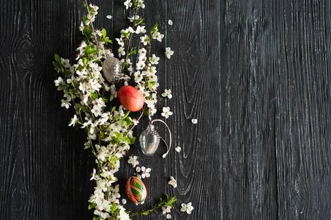 Spring cherry blossoms and Easter eggs on old wooden background. Stock Photos