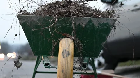 Spring Clean-Up Triumph: Wheelbarrow Laden with Dry Grass - 4K Stock Footage 265709304