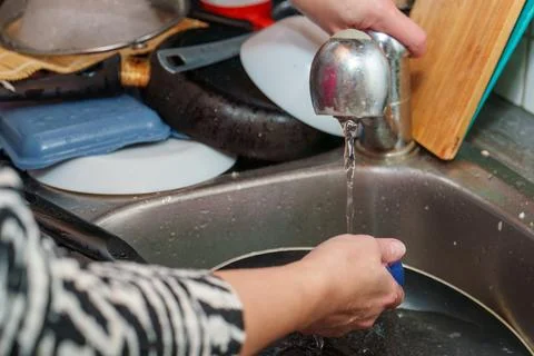 Spring cleaning in kitchen means a mountain of dirty dishes and aching hands Stock Photos