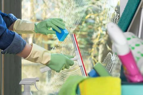 Spring cleaning of a window with a squeegee on a sunny warm day. Clean and .. Stock Photos