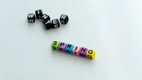 Spring coming and changing winter. Spring concept. Colorful letter beads on Stock Photos