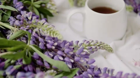 Spring composition with flowers and a cup of tea on a white sheet. flowers and a Stock-Footage 142647731