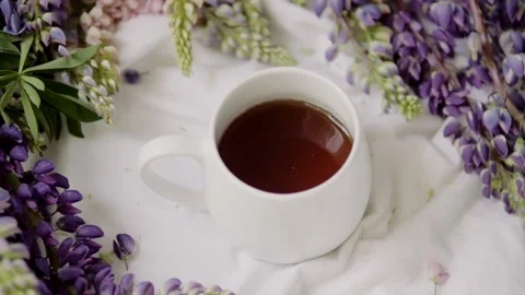 Spring composition with flowers and a cup of tea on a white sheet. flowers and a 動画素材 142744193