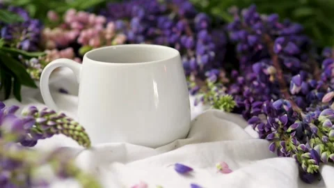 Spring composition with flowers and a cup of tea on a white sheet. flowers and a Видео 142853540