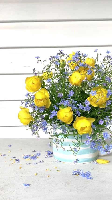 Spring composition with garden yellow and blue flowers in a blue ceramic cup on  스톡 동영상 273825494