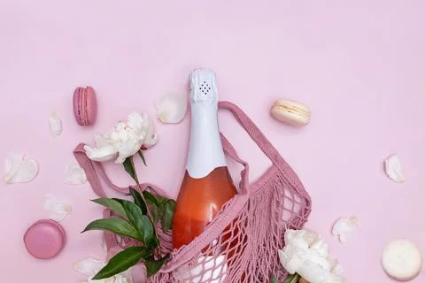 Spring composition with rose sparkling wine, white peonies and macarons Fotos Stock