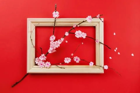 Spring composition with tree branch with paper sakura flowers through wooden  Stock Photos