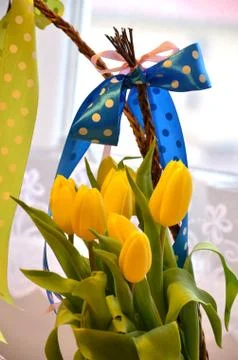 Spring composition: two easter whips with bunch of yellow tulips Stock Photos