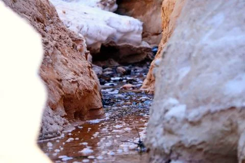 Spring creek between two steep sandy banks with snow Stock Photos