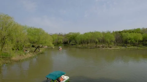 In the spring cruises through the park river under blue sky 스톡 동영상 107754806