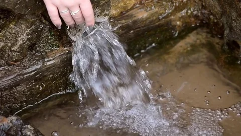 Spring, the current from the pipe. Female hand under the water Stock Footage 69834966