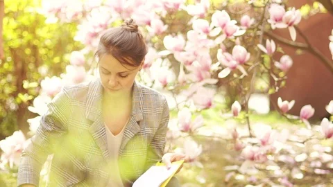 Spring day, mother and son teenager on a background of blooming magnolia. Picnic Stock Footage 118957877