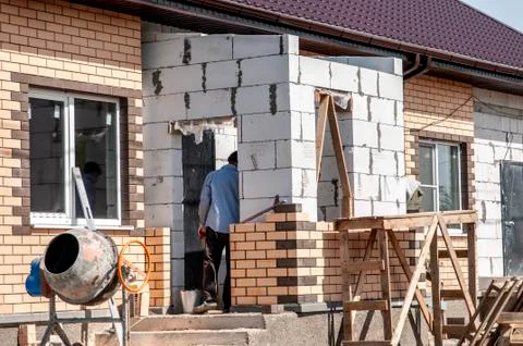 Spring day, workers make the finish facade of the house Foto stock