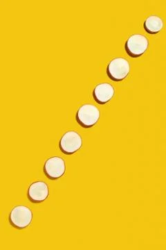 Spring diagonal pattern from fresh radish slices on a yellow background with Foto stock