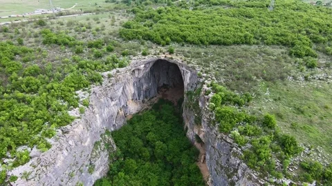 Spring Drone View of Prohodna Cave "God's Eyes" near Karlukovo Stock Footage 323382663
