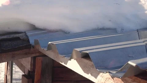 Spring drops slow-motion shooting. Meltwater drips from the roof on a sunny s Stock Footage 186789812